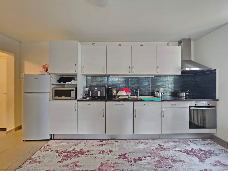 modern kitchen, white cabinets, stainless steel appliances, gas stove, oven, refrigerator, microwave, countertop with sink and faucet