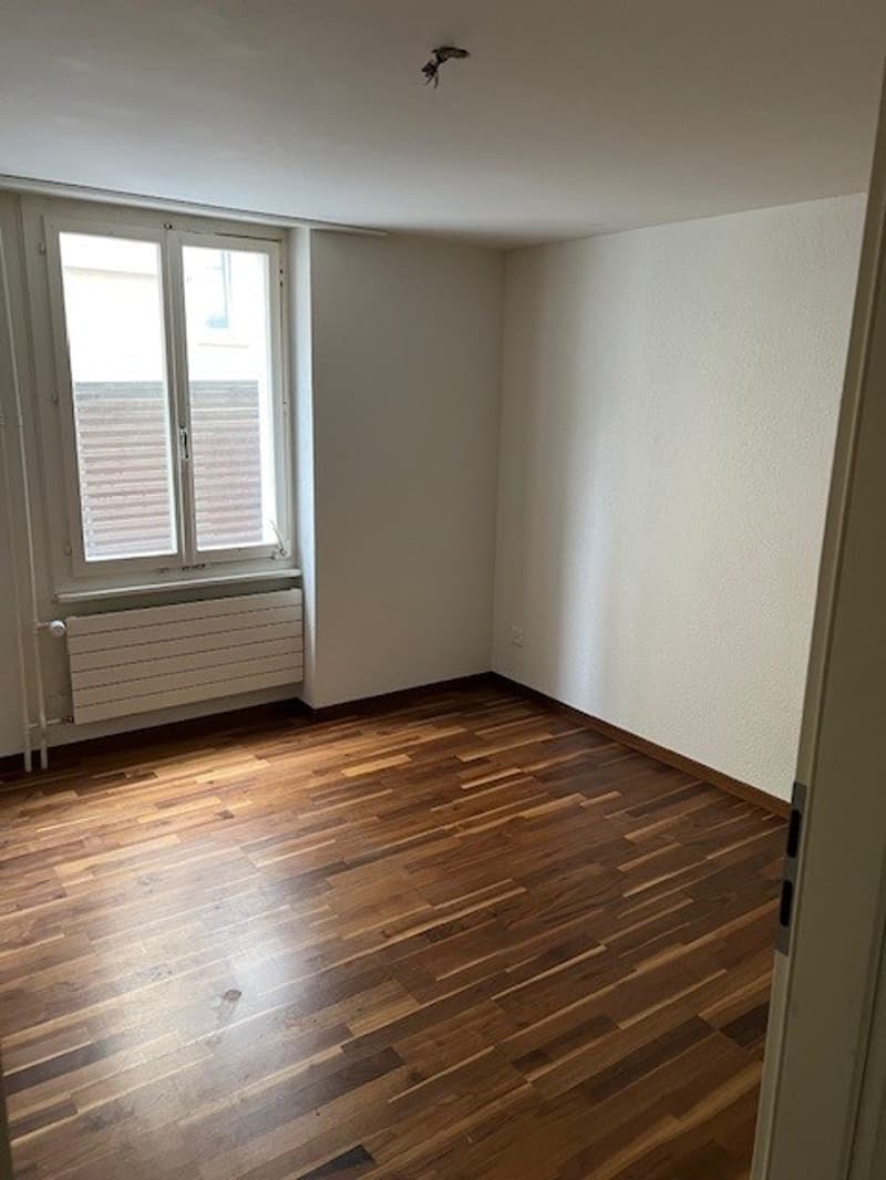 empty room, wooden floor, white walls, window, radiator