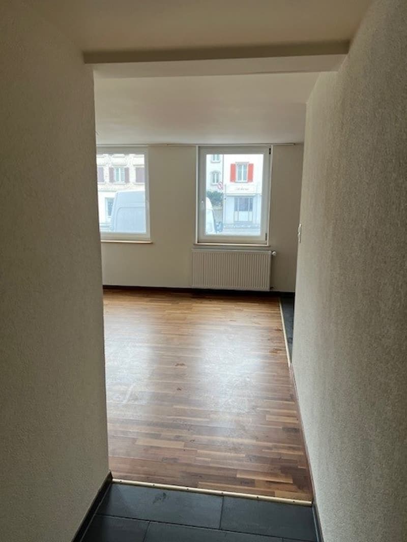 empty room, wooden floor, white walls, windows, white radiator, daylight