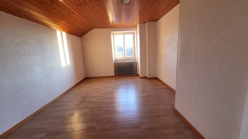Empty room, wooden ceiling, wooden floor, white walls, radiator