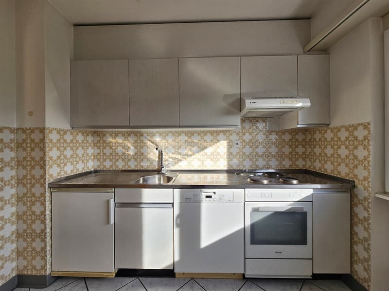 modern kitchen, stainless steel countertops, tiled backsplash, built-in oven, dishwasher, sink with faucet, wooden cabinets, granite countertop, appliances including refrigerator, dishwasher, and stove