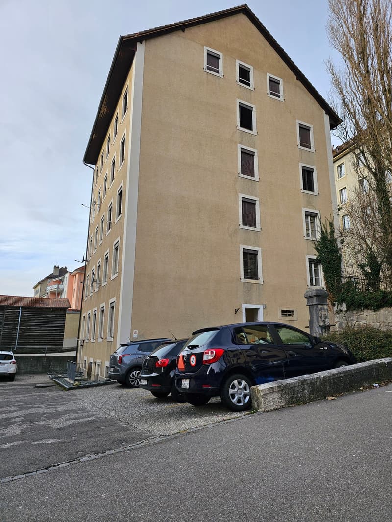 multistory residential building, beige paint, multiple windows, three cars parked in front