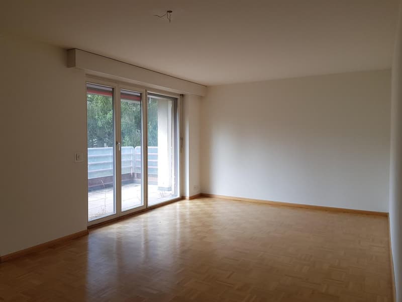 empty room, hardwood floors, sliding glass doors leading to balcony, white walls