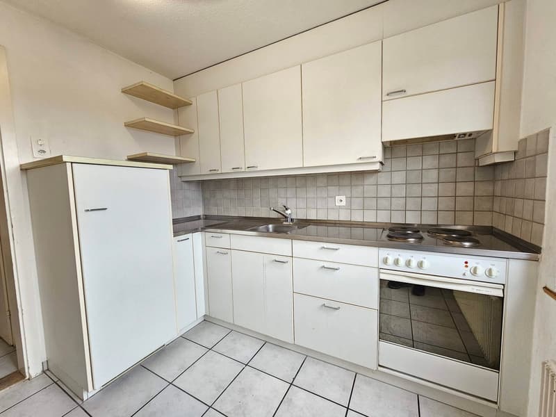 modern kitchen with white cabinets, tiled floor, stainless steel countertop, sink, faucet, gas stove, oven, power outlet, shelves