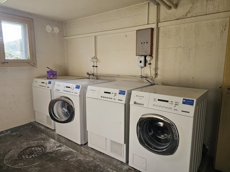 Three washing machines and one dryer in a room