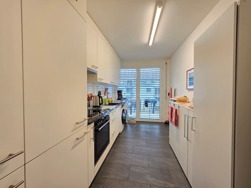 modern kitchen, white cabinets, black appliances, tiled floor, large windows, dishwasher