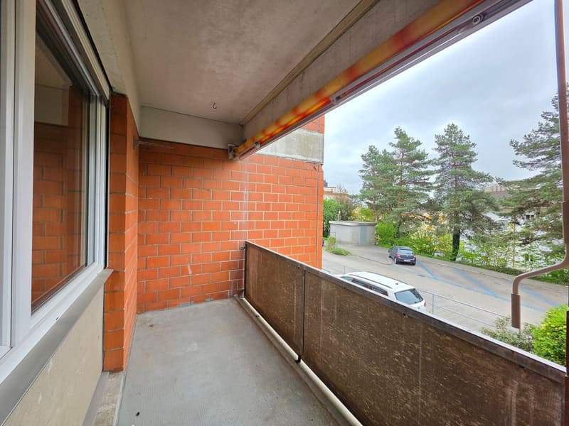 Balcony with brick wall, metal railing, and a view of the street