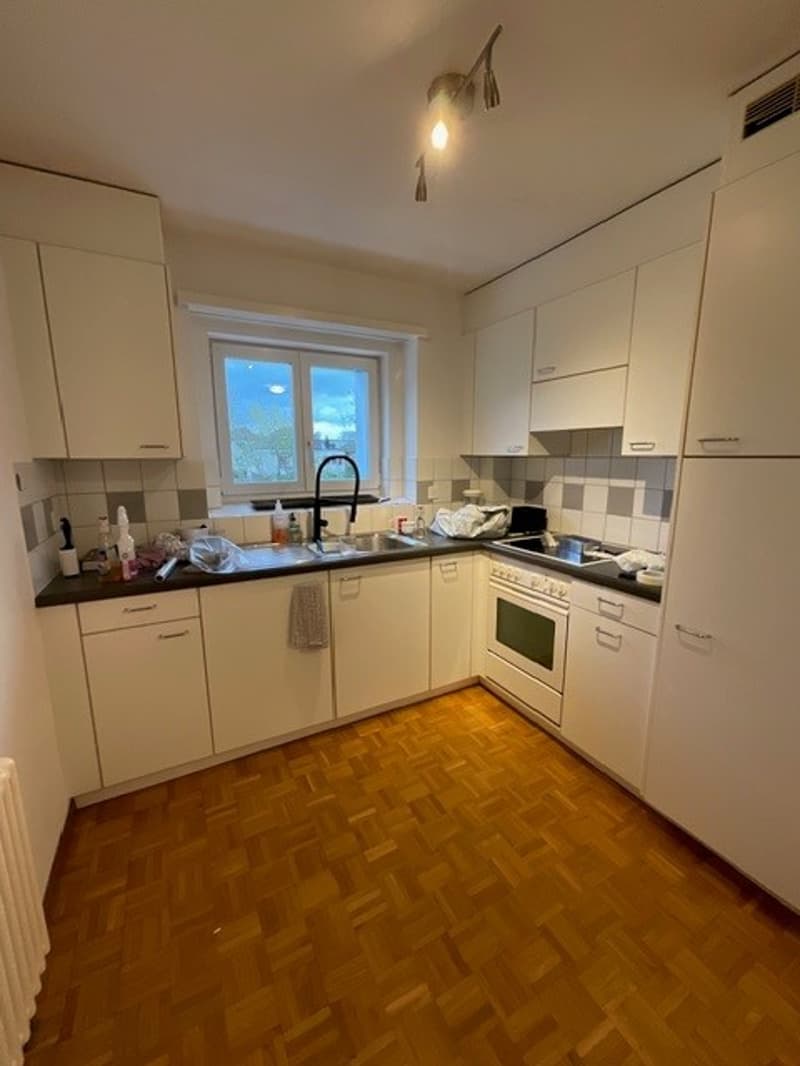 modern kitchen with white cabinets, wooden floor, white appliances, sink, oven, window