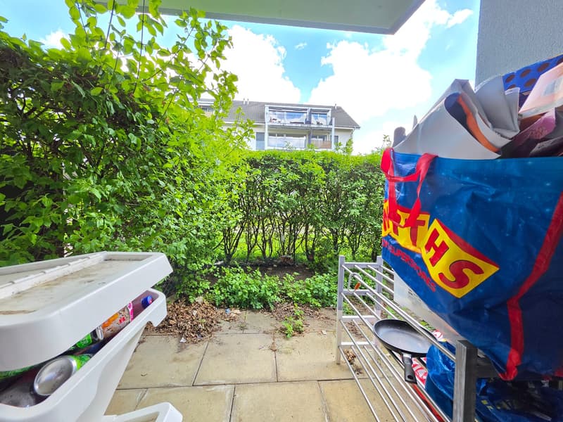 Patio with plants, a storage box, and a bag of trash
