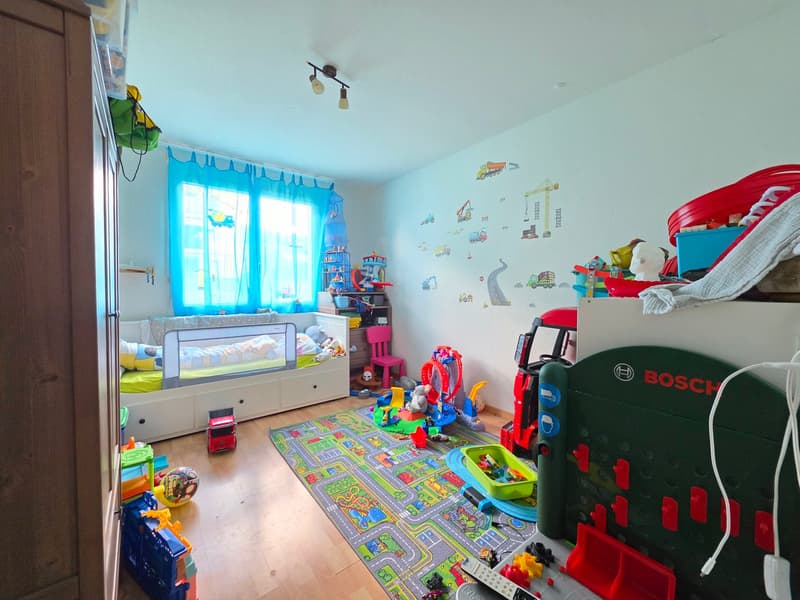 Child's room with bed, toys, rug, and wall decals