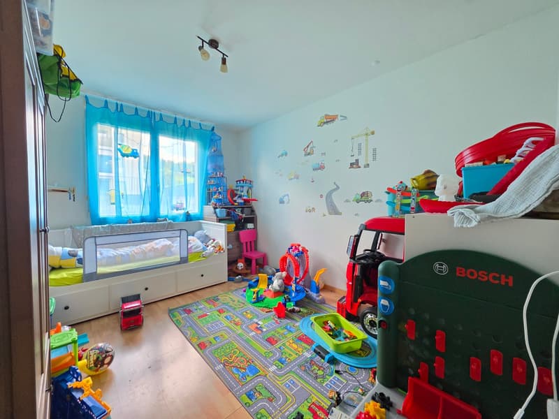 Child's room with bed, toys, rug, and wall decals