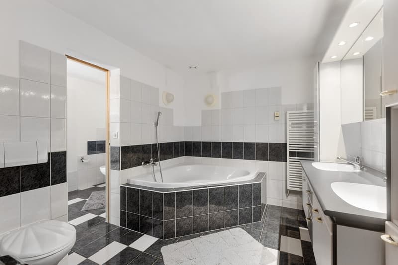 Badezimmer mit Eckbadewanne und Verbindung zur Dusche