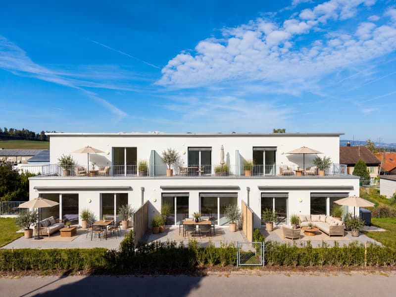 Moderne Terrassenmöblierung am weißen Wohnhaus