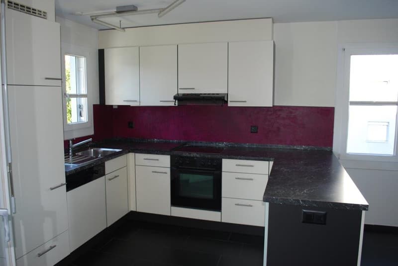 modern kitchen with black countertops, white cabinets, oven, stove, stainless steel sink, refrigerator, windows