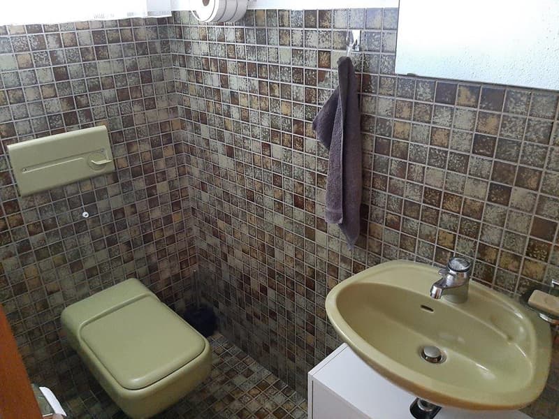 small bathroom with toilet, sink, and towel rack