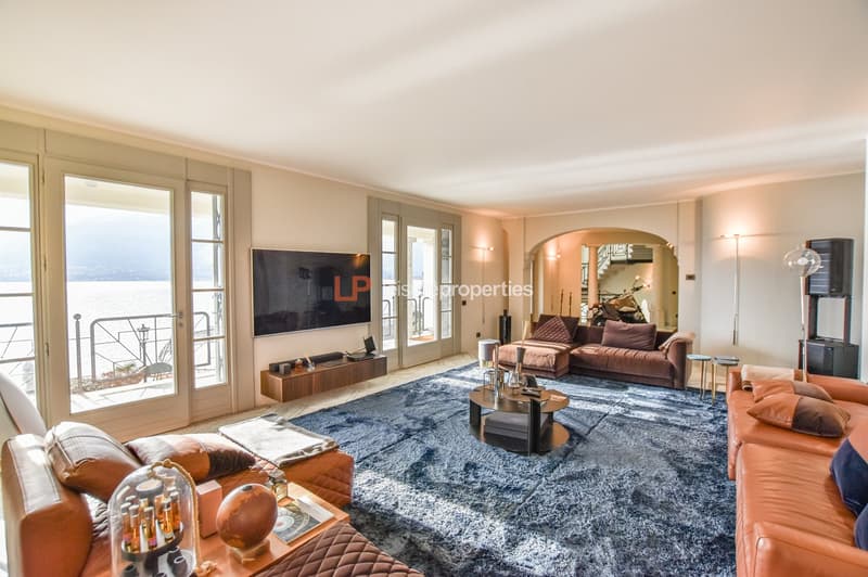 two couches, coffee table, large windows with balcony, large flat screen TV