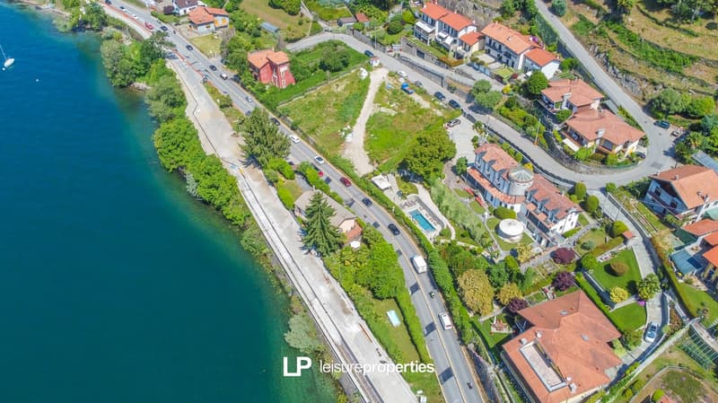 hillside residential area, several houses, swimming pool, greenery, nearby road, waterfront