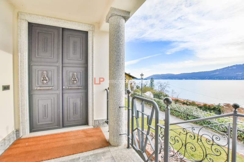 grey double doors, red carpet, wrought iron railings, metal posts, balcony, lake, mountains