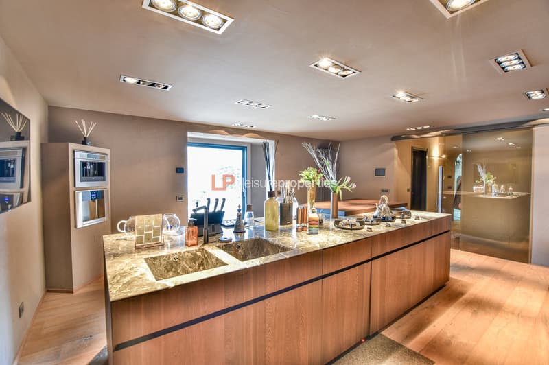 modern kitchen island with two sinks, built-in appliances, and granite countertop