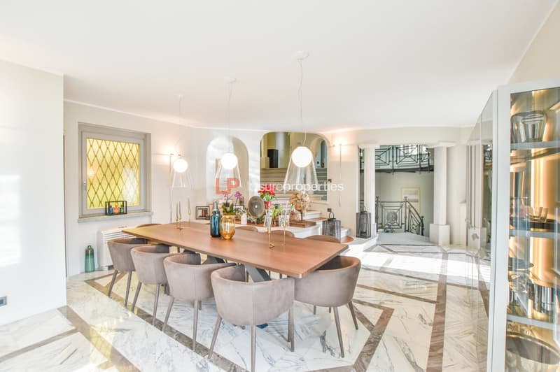 large wooden table, grey chairs, marble floor, large windows, decorative objects, hanging lamps, large cabinet