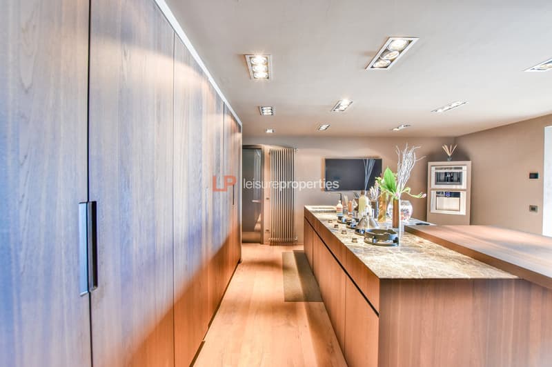 modern kitchen with wooden countertops, large wooden cabinetry, radiator, microwave, fridge, dining area