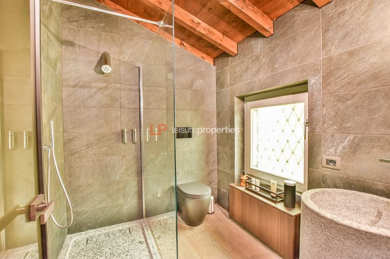 shower, toilet, sink, wooden flooring, tiled walls, wooden beam ceiling, glass window
