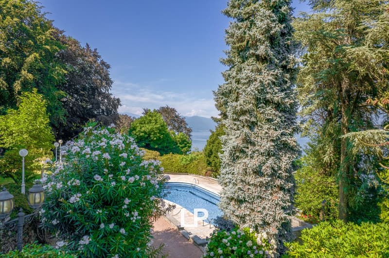 Outdoor pool, lush greenery, swimming pool, view of the lake and mountains, well-maintained garden, pathway leading to the pool
