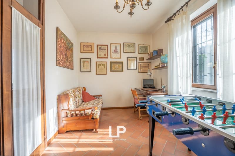 wooden couch, foosball table, wooden desk, wooden chair, chandelier, paintings, window, curtain