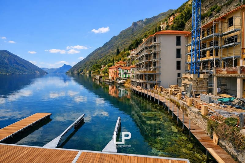 Coastal building with many floors, mountains, lake, dock, boats, and construction site.