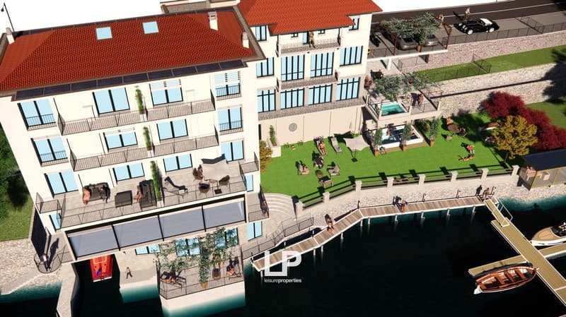 Modern multi-story building with balconies, large windows, rooftop swimming pool, and beautiful lake view