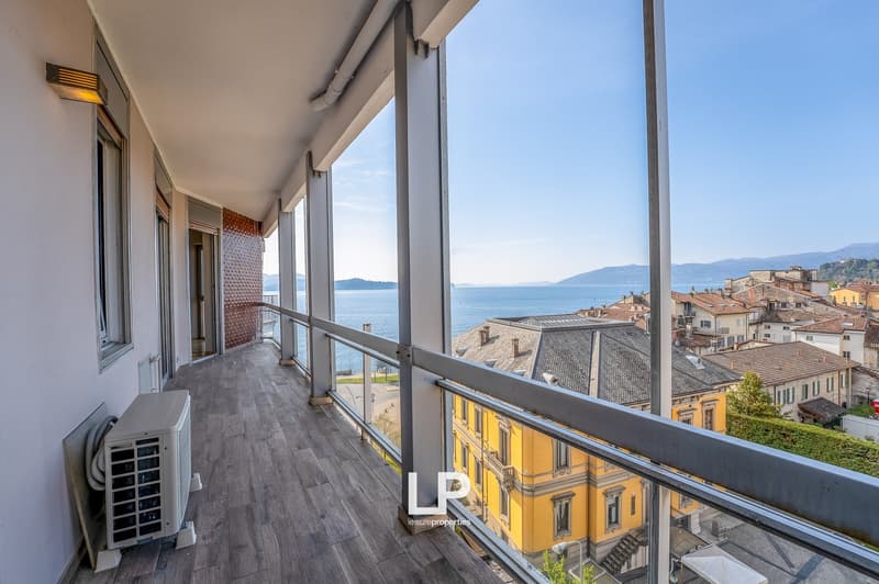 Spacious balcony with panoramic views of the lake and surrounding buildings, hardwood flooring, large windows, air conditioning unit
