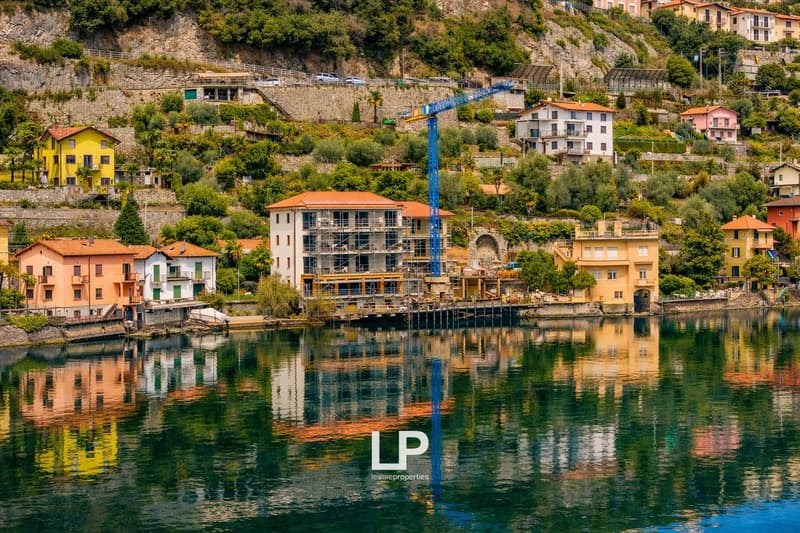 Lakefront, residential properties, trees, construction crane, reflection in the water