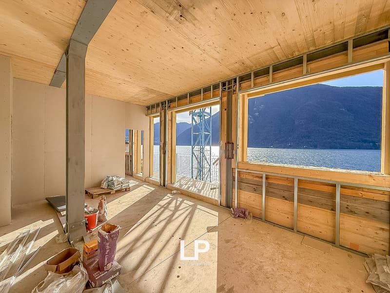 wooden ceiling, walls under construction, large windows with a lake view, bare floor