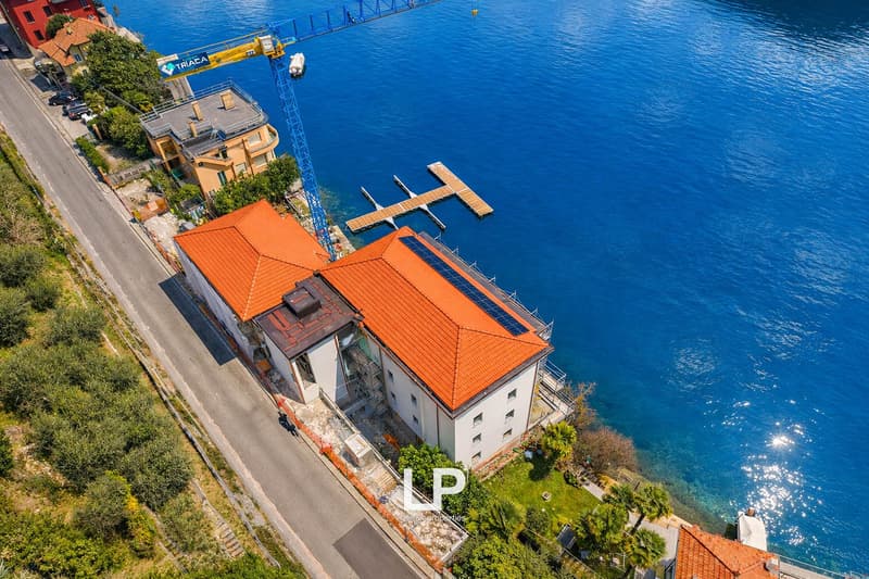 House on waterfront, red roof, windows, solar panels, dock, road
