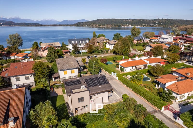 multiple houses, red roofs, solar panels, trees, swimming pool, lake