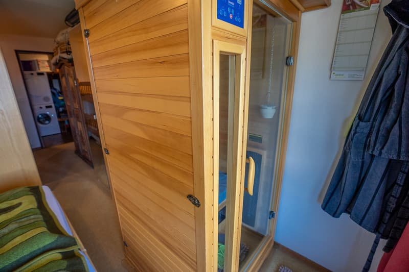 The image shows a small room with wooden paneled walls, a washing machine, and a refrigerator visible.