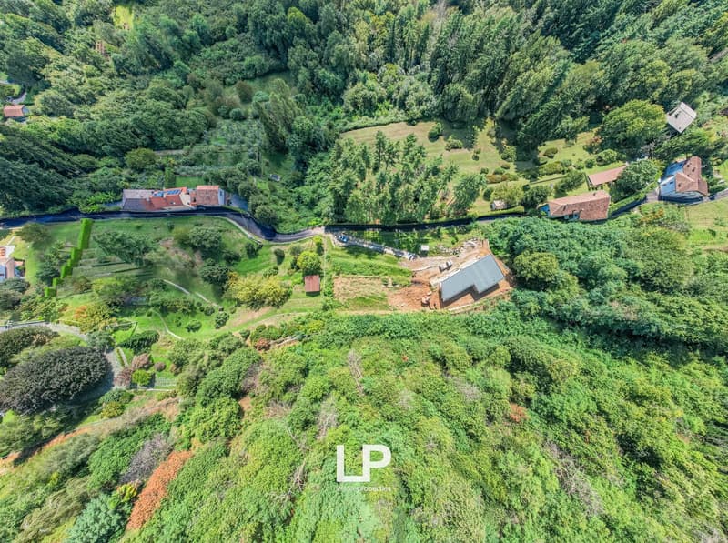 Countryside with multiple residential buildings, greenery, roads, and construction
