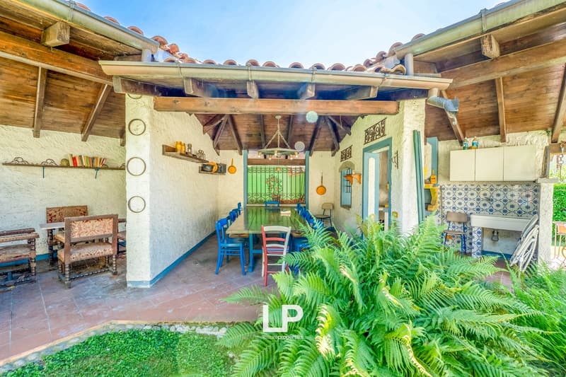 Wooden ceiling, blue doors, tile floor, table and chairs, fireplace, potted plants, green lattice window