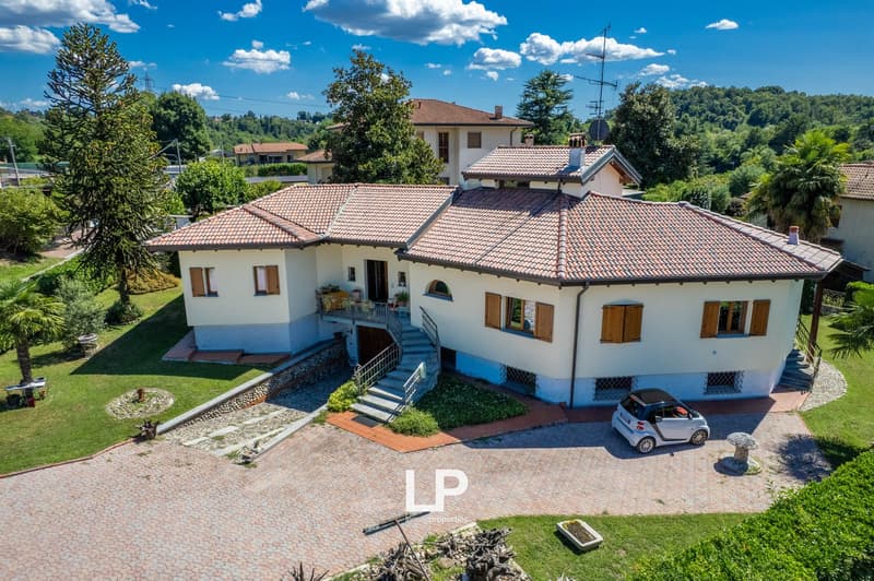 Detached house, two-story, red roof, white walls, paved driveway, garden, staircase to entrance, car parked in front