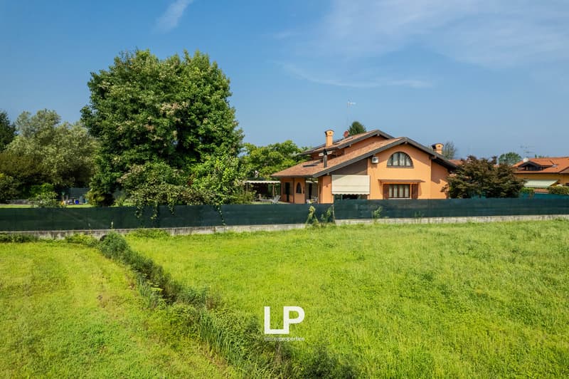 Single-family house, orange exterior, large garden, fenced, solar panels on the roof