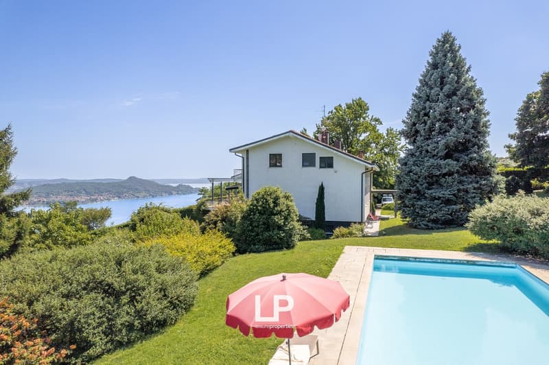 modern house, white exterior, surrounded by trees, lake view, pool, open space with lawn, terrace