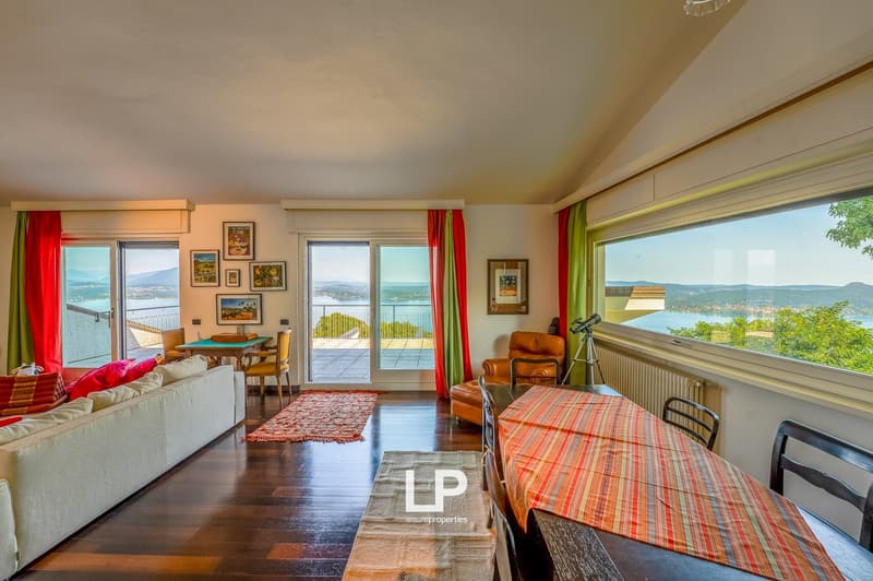 wooden floors, open floor plan, large windows, balcony, view of the lake, dining table, chandelier