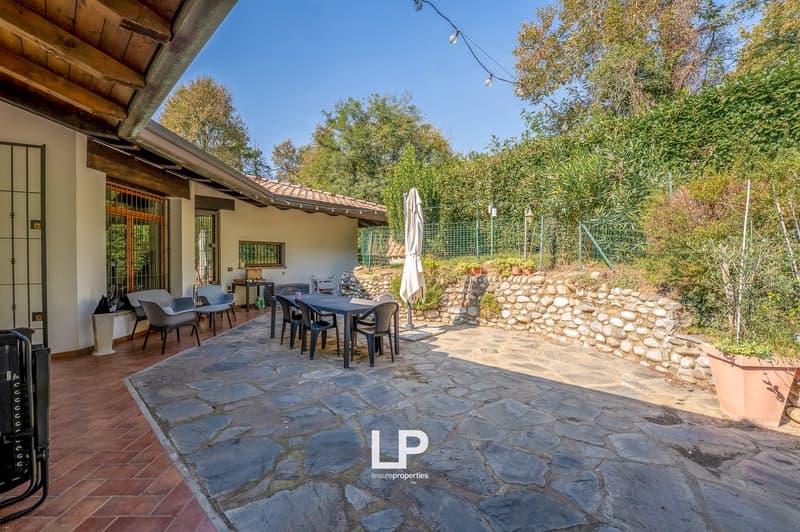 stone pathway, table and chairs, closed gate, wall with stones, potted plants