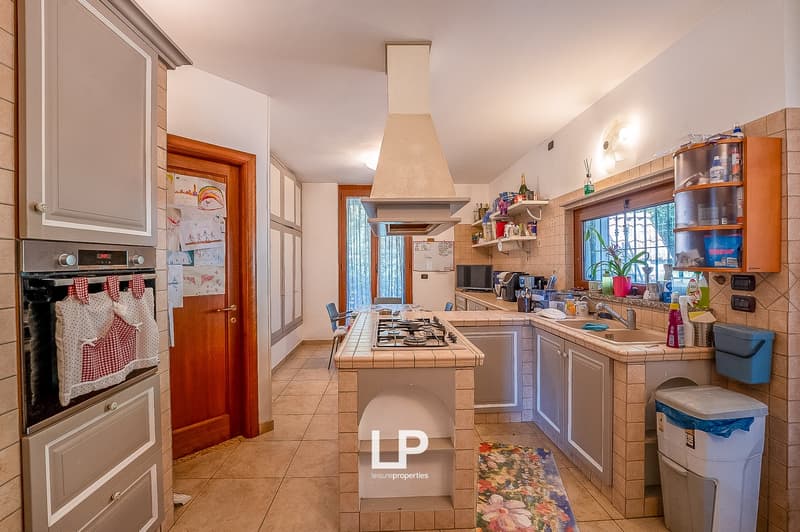 modern kitchen with island, gas stove, oven, sink, cabinets, tiled floor, window
