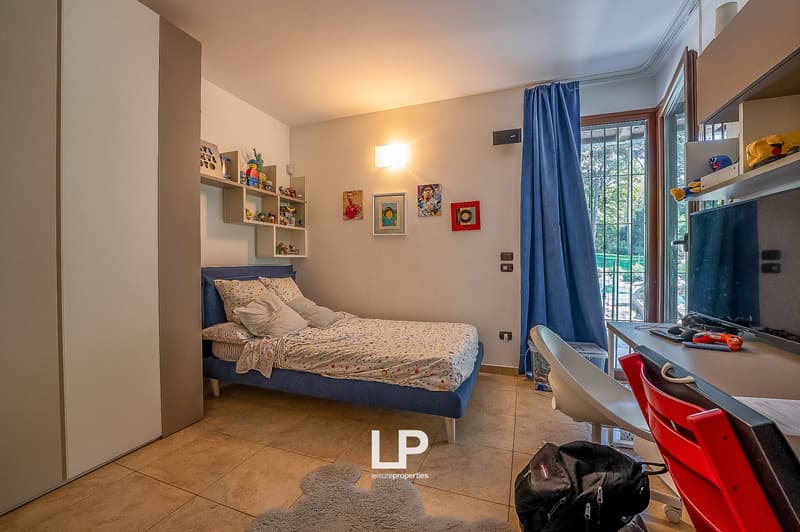bedroom with bed, desk, chairs, shelves with toys, rug, and a view of the outside
