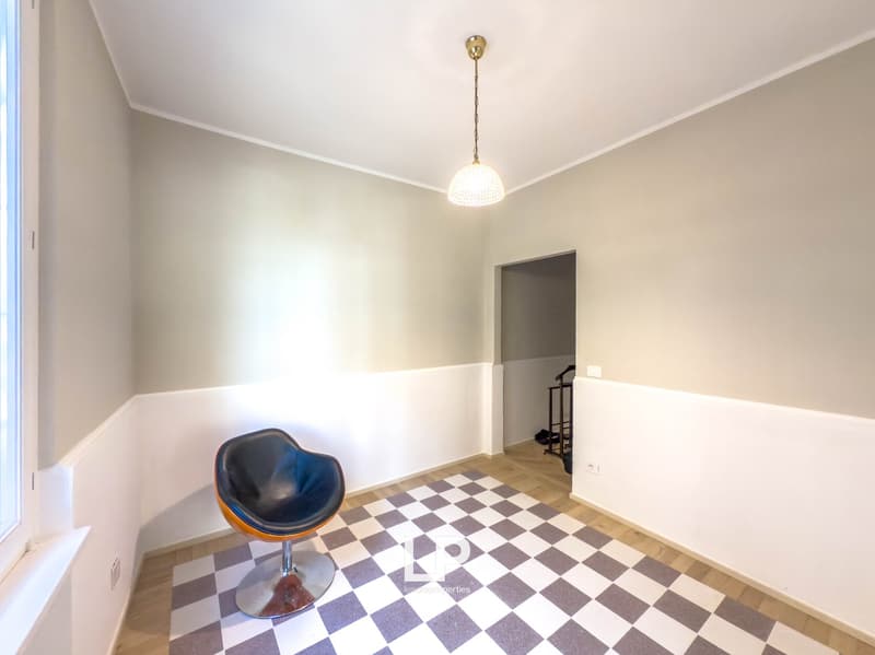 empty room, wooden floor, white and gray walls, checkered floor, pendant light, chair