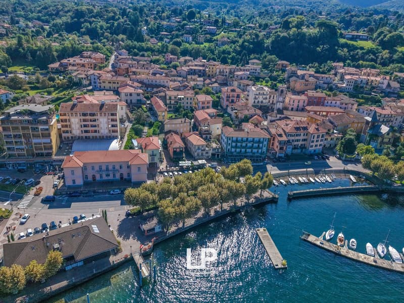 aerial view of a town with many buildings, a harbor with boats, and a scenic view of the mountains