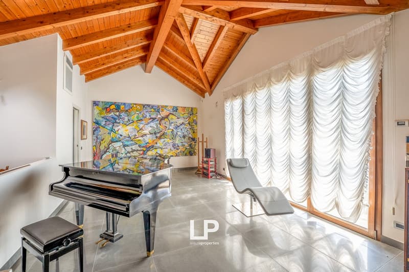 spacious room with high ceilings, black grand piano, modern decor, large window, lounge chair, artwork on wall