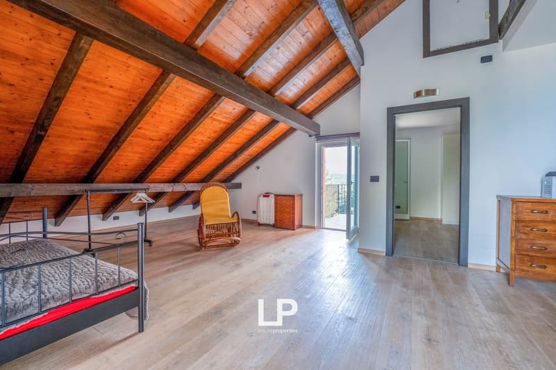 wooden beams ceiling, double bed, wicker chair, wooden desk, open door with balcony access, wooden floor, windows