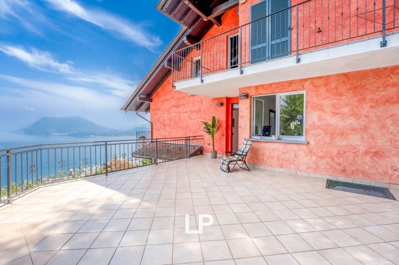 Two-story house with tiled roof, balcony, orange walls, tiled floor, metal railings, mountain and sea view